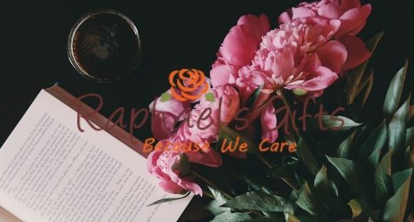An open book and a bunch of pink flowers lying beside it and Raphael's Gift logo in the middle