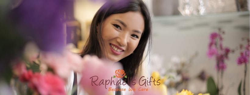 A girl smiling inside a flower shop and Raphael's Gifts logo placed at the middle bottom