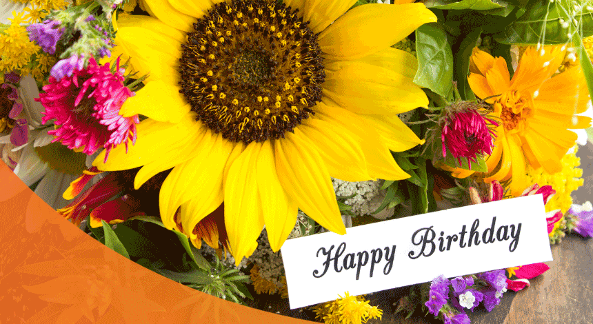 A bunch of flowers with a Happy Birthday greeting card